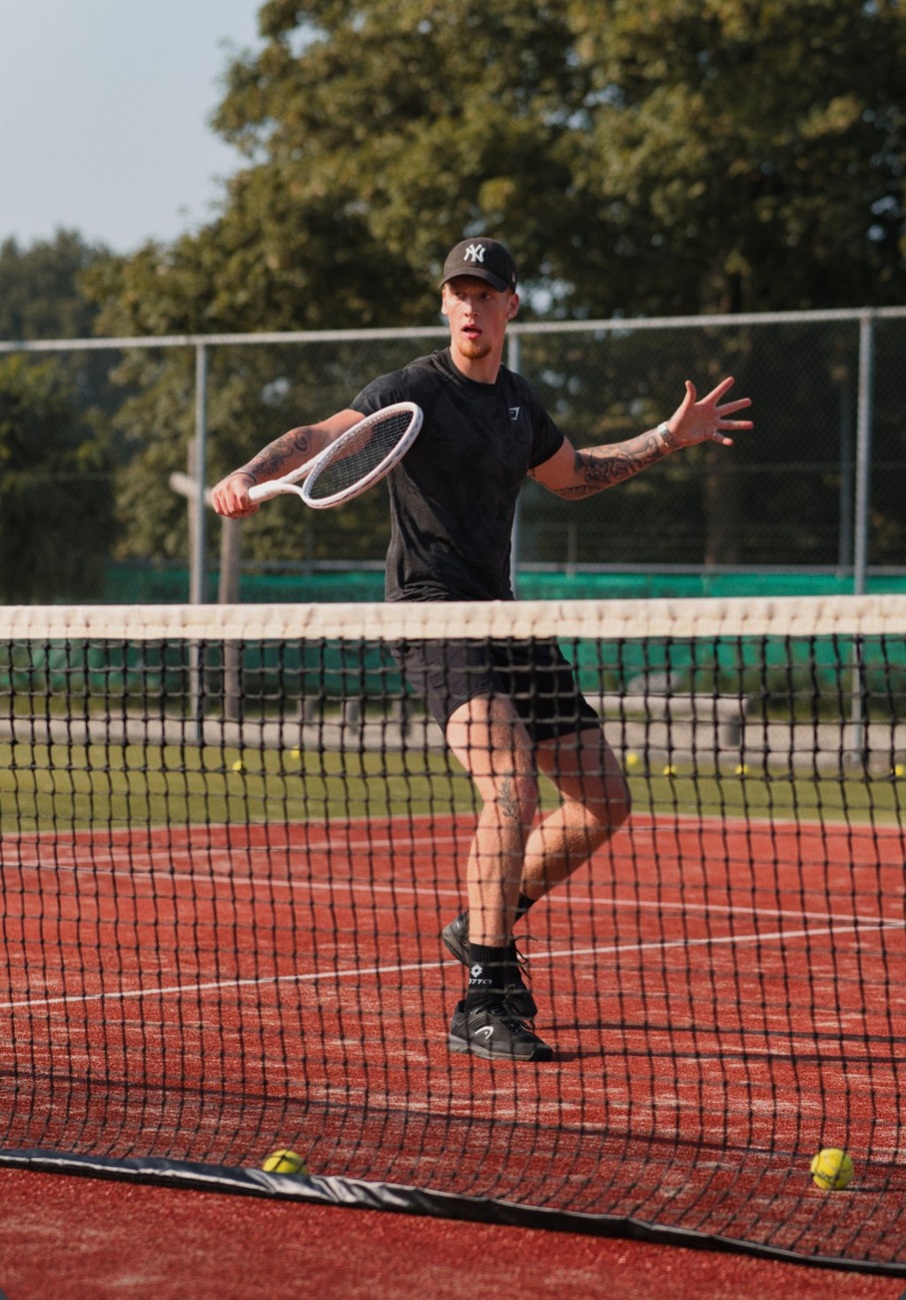Tennistrainer speelt een forehand aan het net