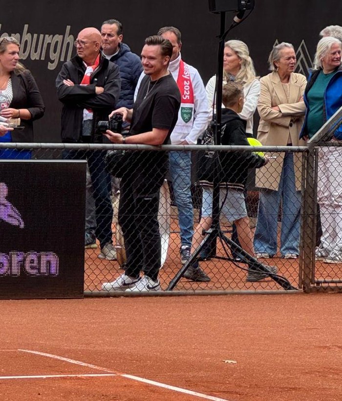 Rene met camera en een brede grijns naast de gravelbaan bij ALTV Daisy